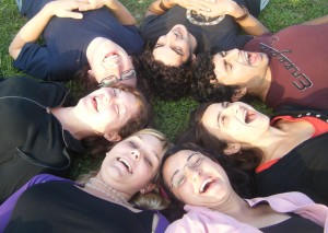 sette ragazzi sorridenti sdraiati su un prato