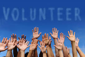 tante braccia alzate sotto alla scritta Volunteer